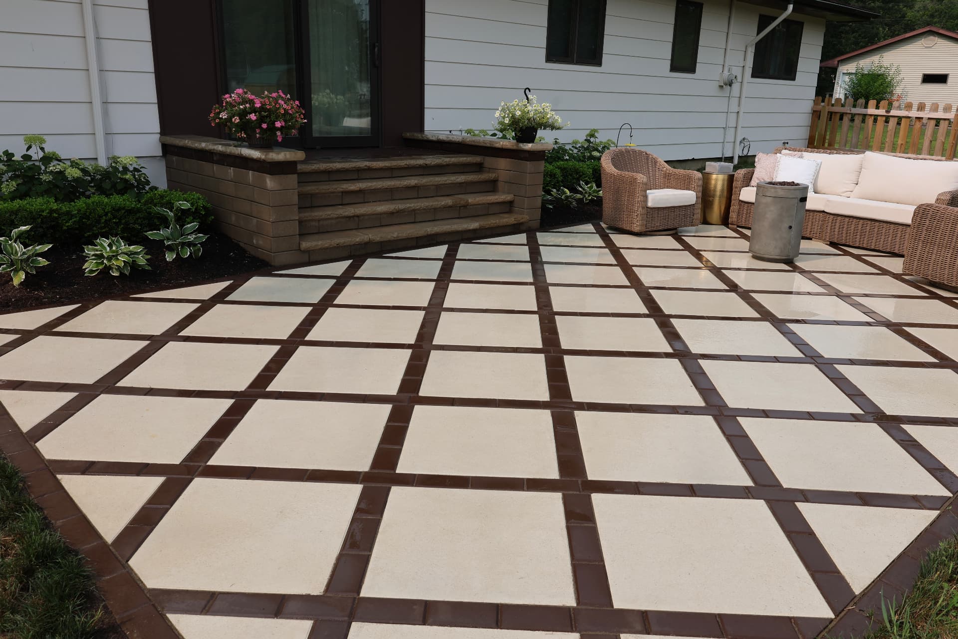 Contemporary cream slab patio with brown banding, seat wall and stone steps